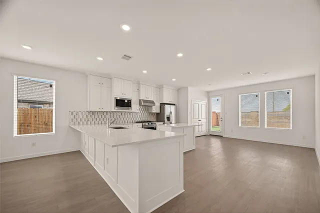 a large white kitchen with a large window