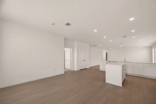 a view of a kitchen with a refrigerator and a stove top oven