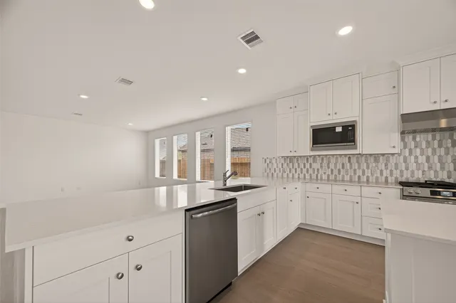a kitchen with granite countertop white cabinets and white appliances
