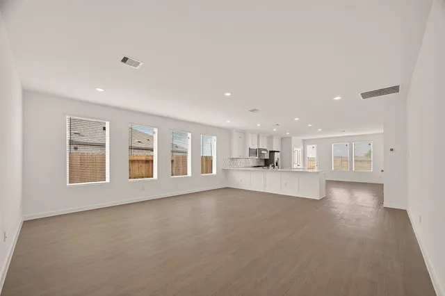 a view of an empty room with a kitchen