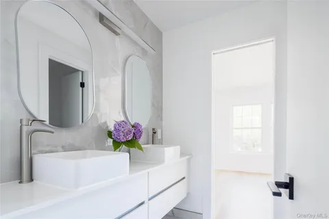 a bathroom with a tub sink and mirror