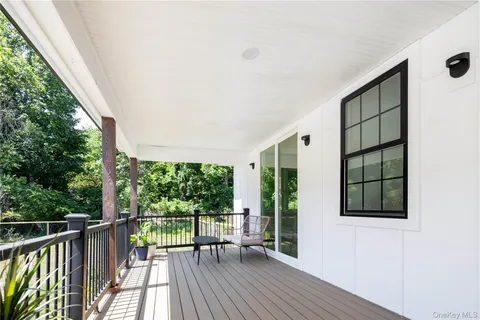 a view of a balcony with chairs and wooden floor
