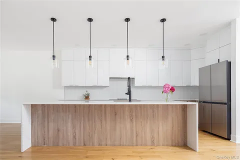a kitchen with kitchen island sink refrigerator and cabinets