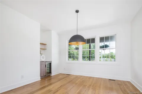 a view of empty room with wooden floor and windows