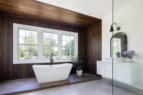 a white bath tub sitting in a bathroom next to a window