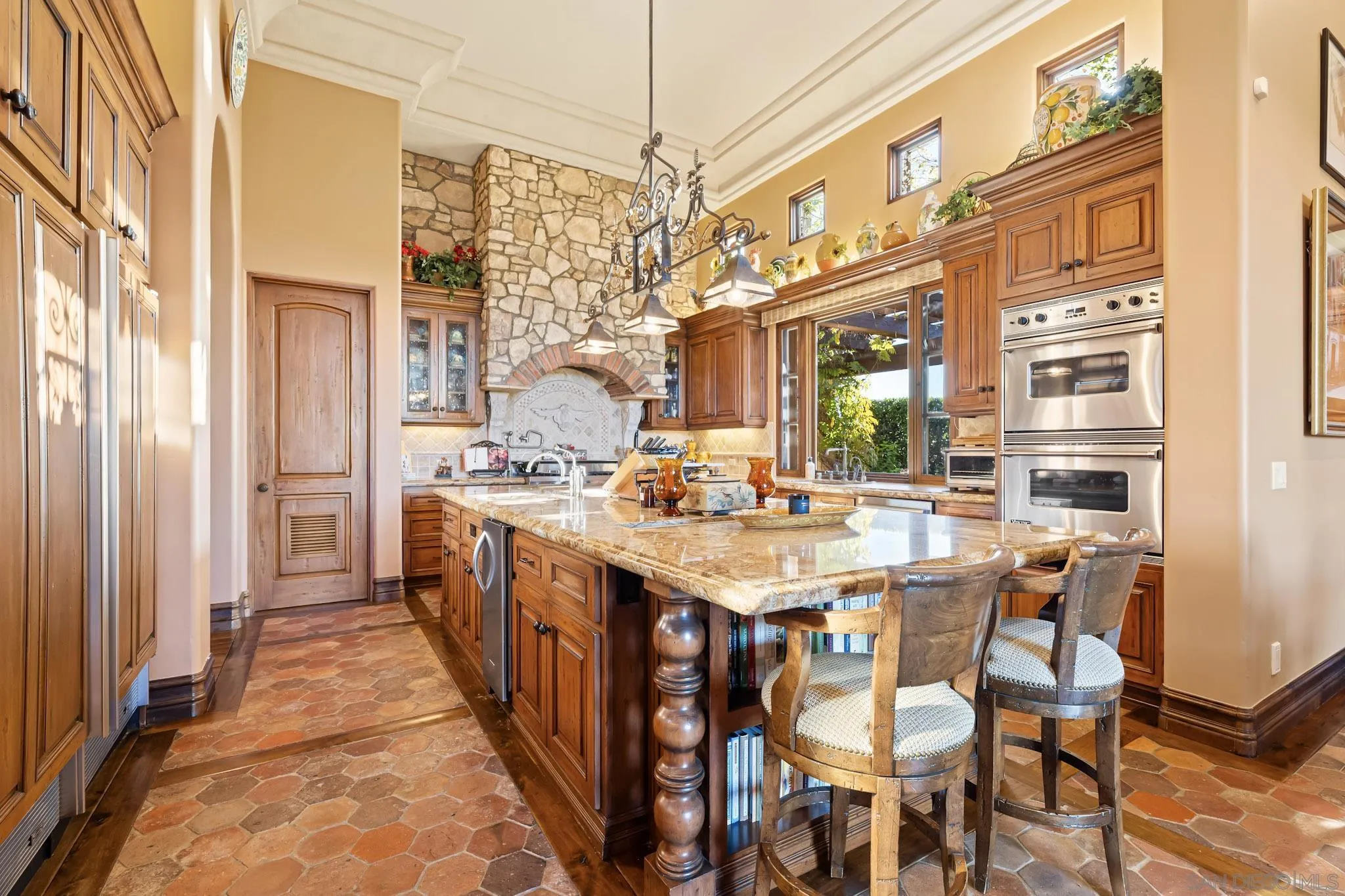 18486 Via Candela Rancho Santa Fe, CA 92091 - Photo 10 of 34 a kitchen with stainless steel appliances granite countertop a dining table chairs and a refrigerator