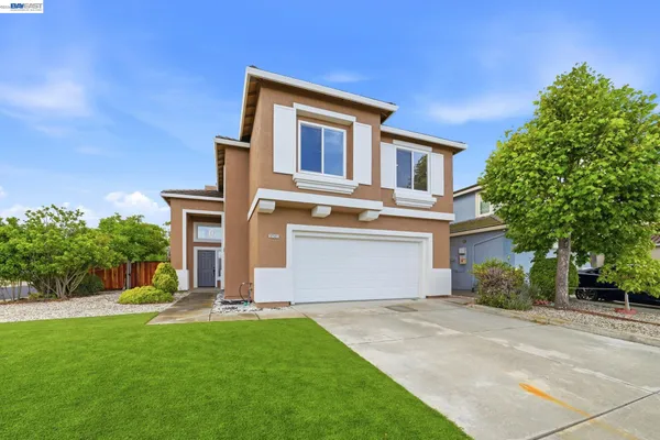 a front view of a house with a yard and garage