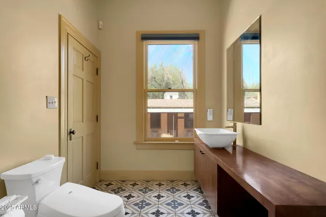 a bedroom with a bed and a dresser with mirror