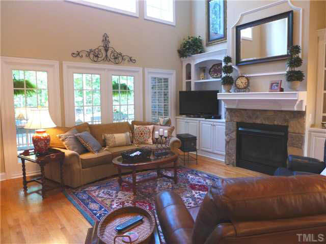 7209 Sparhawk Road Wake Forest, NC 27587 - Photo 6 of 25 Straight ahead is the spacious 2-story tall Family Rm w/stone gas log FP flanked by cabinets/bookshelves, wall of windows, recessed lighting & ceiling fan open to the spacious Kitchen & Bfast area. Den/Family/Great Room