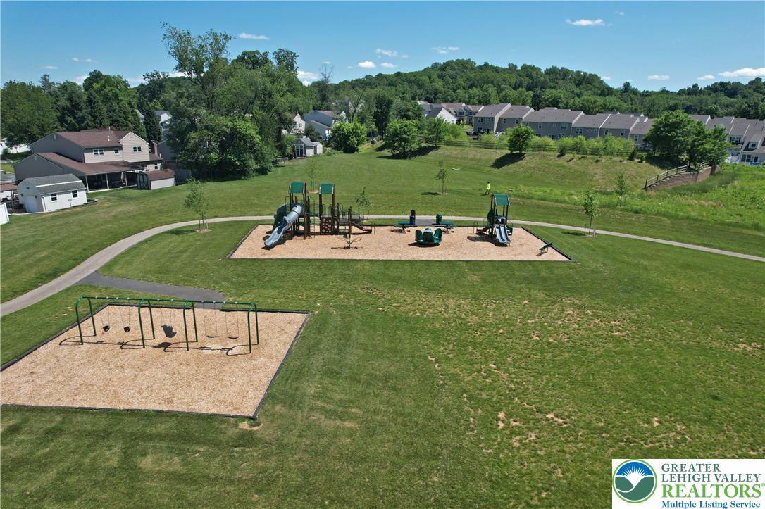 4502 Benjamin Court Emmaus, PA 18049 - Photo 52 of 53 A community playground with swings and slides offers recreation for all ages amidst lush green spaces.
