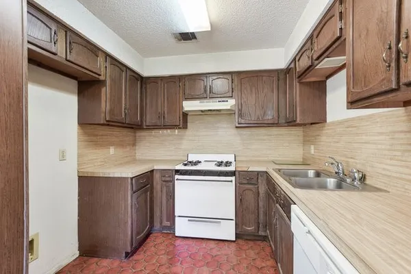 a kitchen with a sink a stove and cabinets