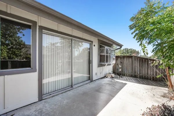 a view of backyard with small cabin and wooden fence