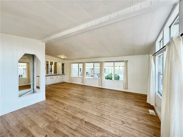 a view of empty room with wooden floor and window