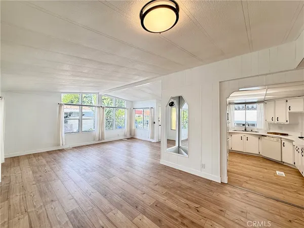 a kitchen with cabinets appliances and wooden floor