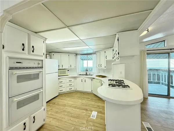 a kitchen with white cabinets and white appliances