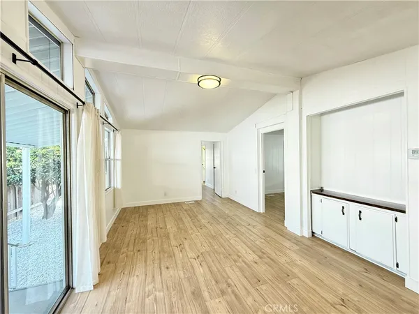 a view of a big room with wooden floor and windows