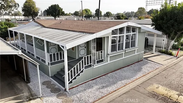 a view of a house with pool and trees in the background