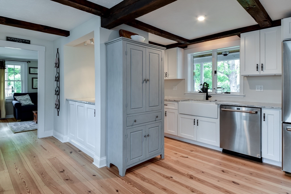 49 Hayden Rowe Street Hopkinton, MA 01748 - Photo 12 of 39 a kitchen with white cabinets and wooden floors