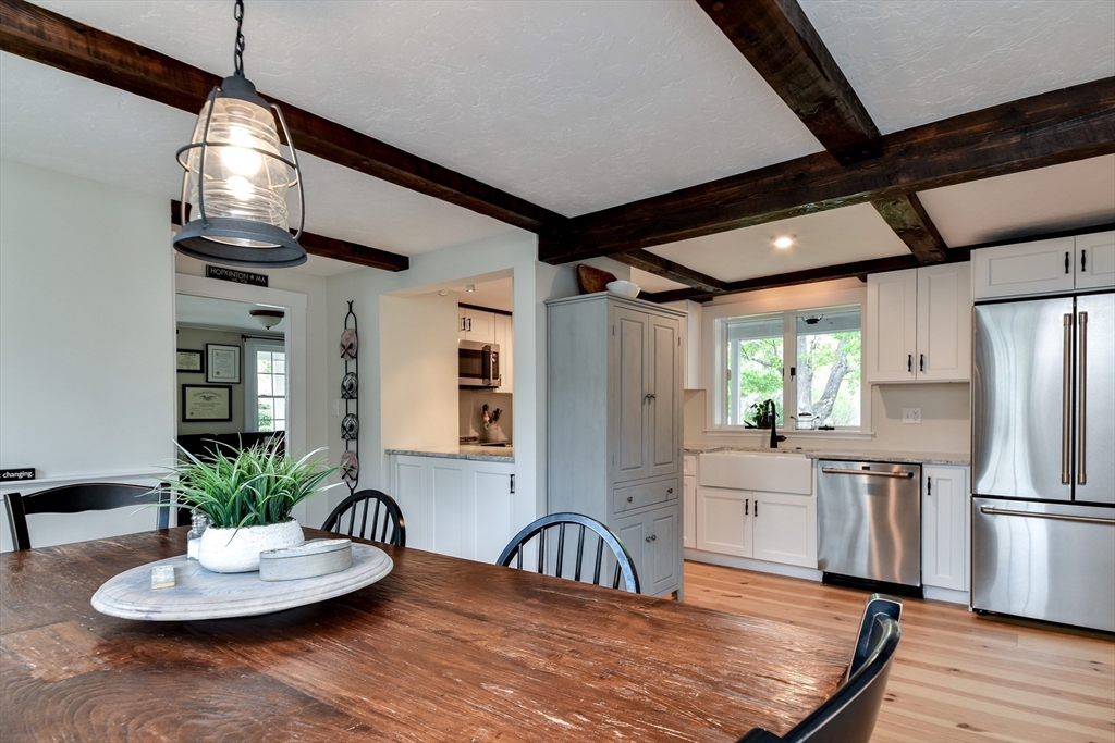 49 Hayden Rowe Street Hopkinton, MA 01748 - Photo 13 of 39 a kitchen with stainless steel appliances a dining table a refrigerator and wooden floor