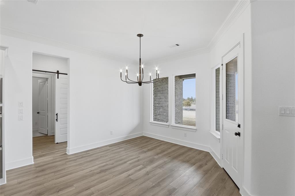 1005 Webb Court Van Alstyne, TX 75495 - Photo 13 of 38 a view of an empty room with wooden floor and a window