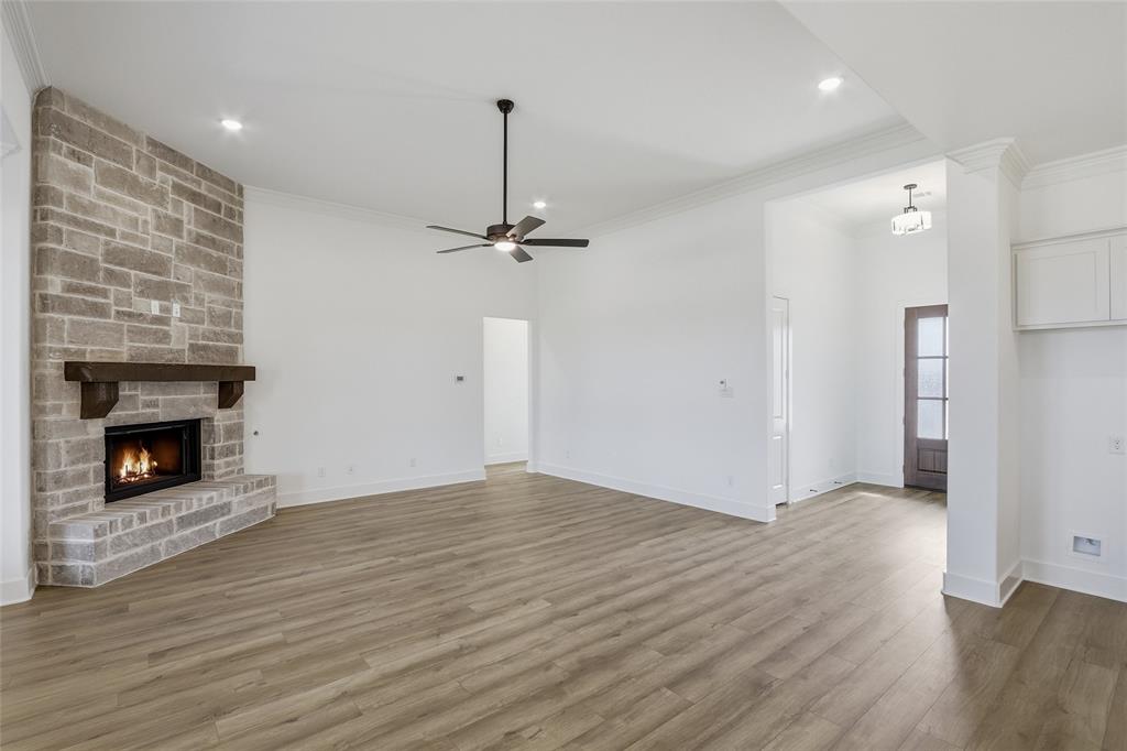 1005 Webb Court Van Alstyne, TX 75495 - Photo 14 of 38 a view of an empty room with wooden floor fireplace and a window