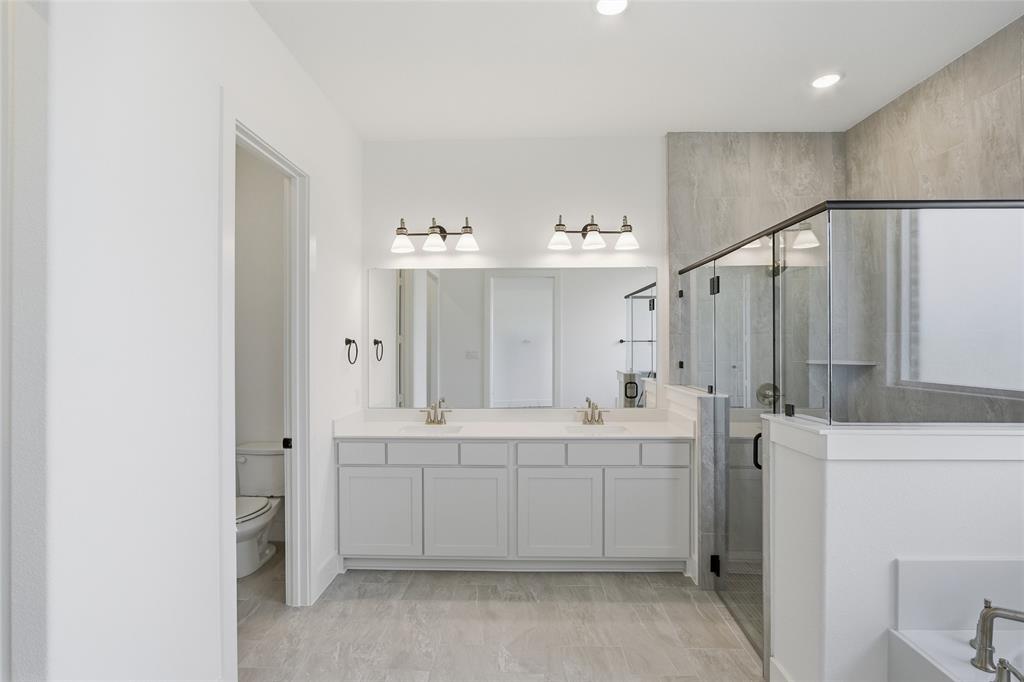 1005 Webb Court Van Alstyne, TX 75495 - Photo 18 of 38 a bathroom with a double vanity sink a toilet and a tub
