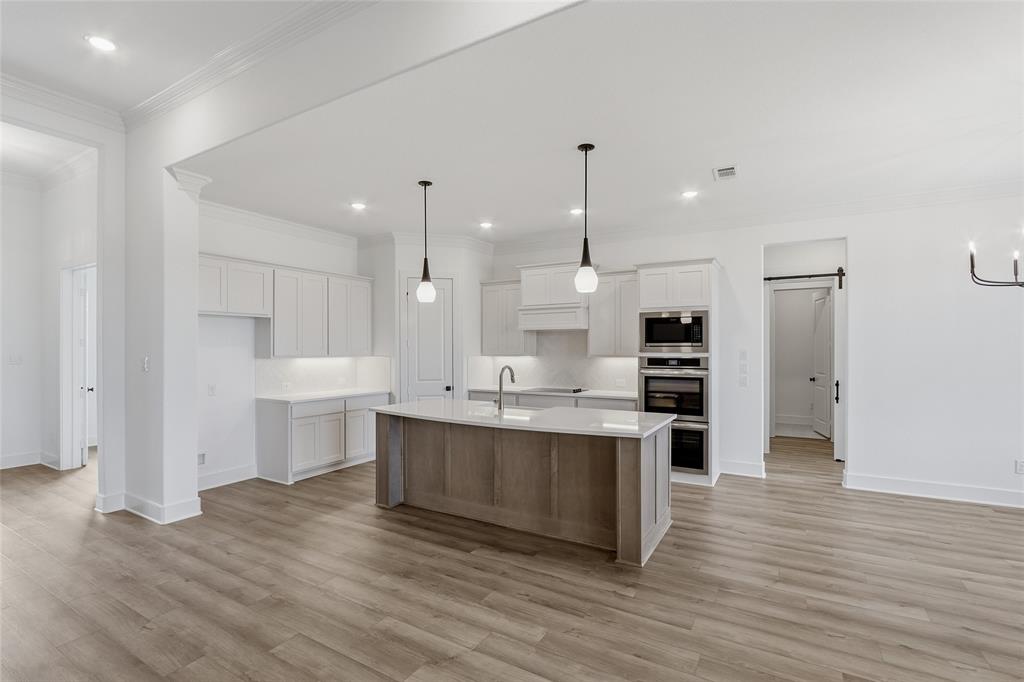 1005 Webb Court Van Alstyne, TX 75495 - Photo 6 of 38 a large kitchen with stainless steel appliances a large counter top and a wooden floors
