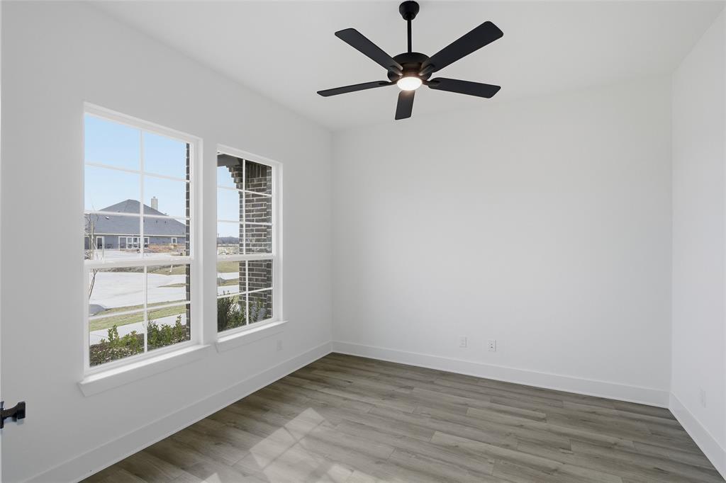 1005 Webb Court Van Alstyne, TX 75495 - Photo 8 of 38 an empty room with wooden floor chandelier fan and windows