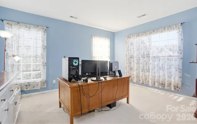 a living room with furniture a air conditioner vent and a window