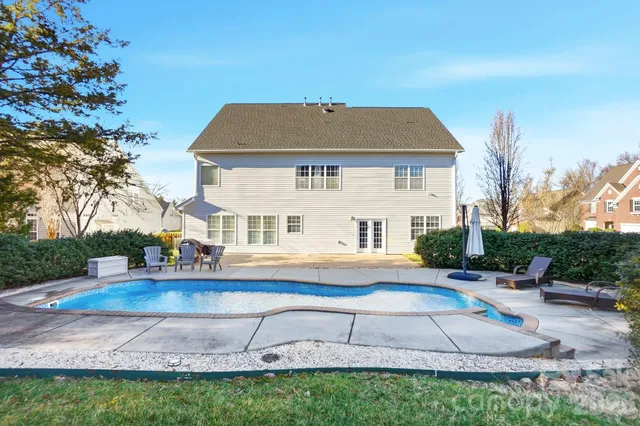 a view of a house with swimming pool and sitting area