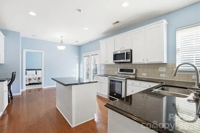a kitchen with kitchen island a stove a sink and a microwave