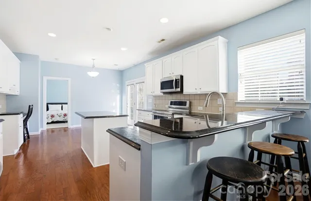 a kitchen with a table chairs a sink dishwasher window and cabinets