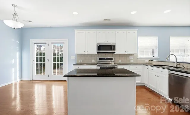 a kitchen with a sink a stove and cabinets