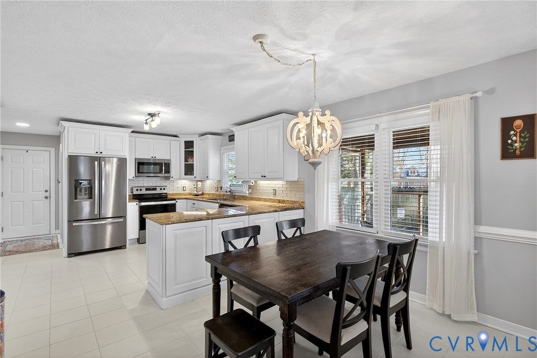 7443 Pinehurst Drive Quinton, VA 23141 - Photo 16 of 49 a kitchen with stainless steel appliances a table chairs and chandelier