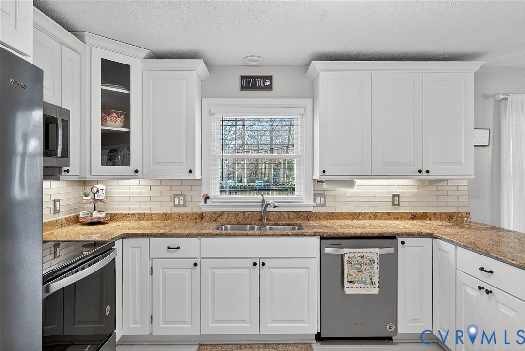7443 Pinehurst Drive Quinton, VA 23141 - Photo 21 of 49 a kitchen with granite countertop a sink stove and cabinets
