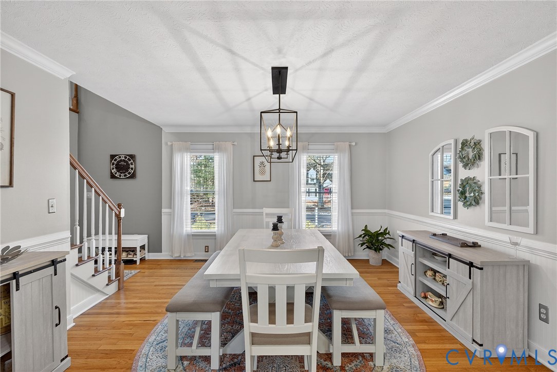 7443 Pinehurst Drive Quinton, VA 23141 - Photo 25 of 49 a dining room with wooden floor a chandelier a wooden table and chairs