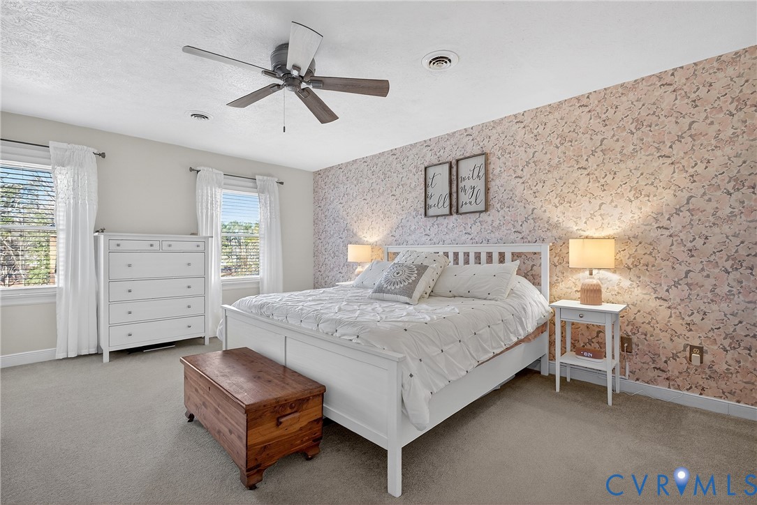 7443 Pinehurst Drive Quinton, VA 23141 - Photo 35 of 49 a spacious bedroom with a bed and a ceiling fan