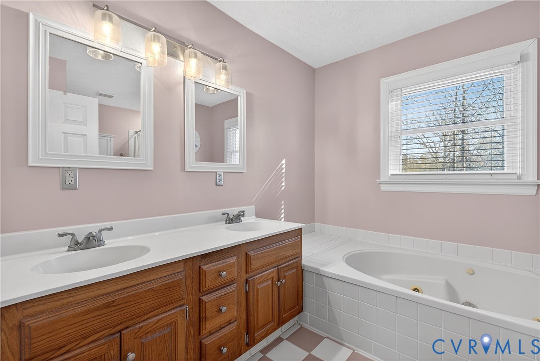 7443 Pinehurst Drive Quinton, VA 23141 - Photo 39 of 49 a bathroom with a tub a sink and mirror