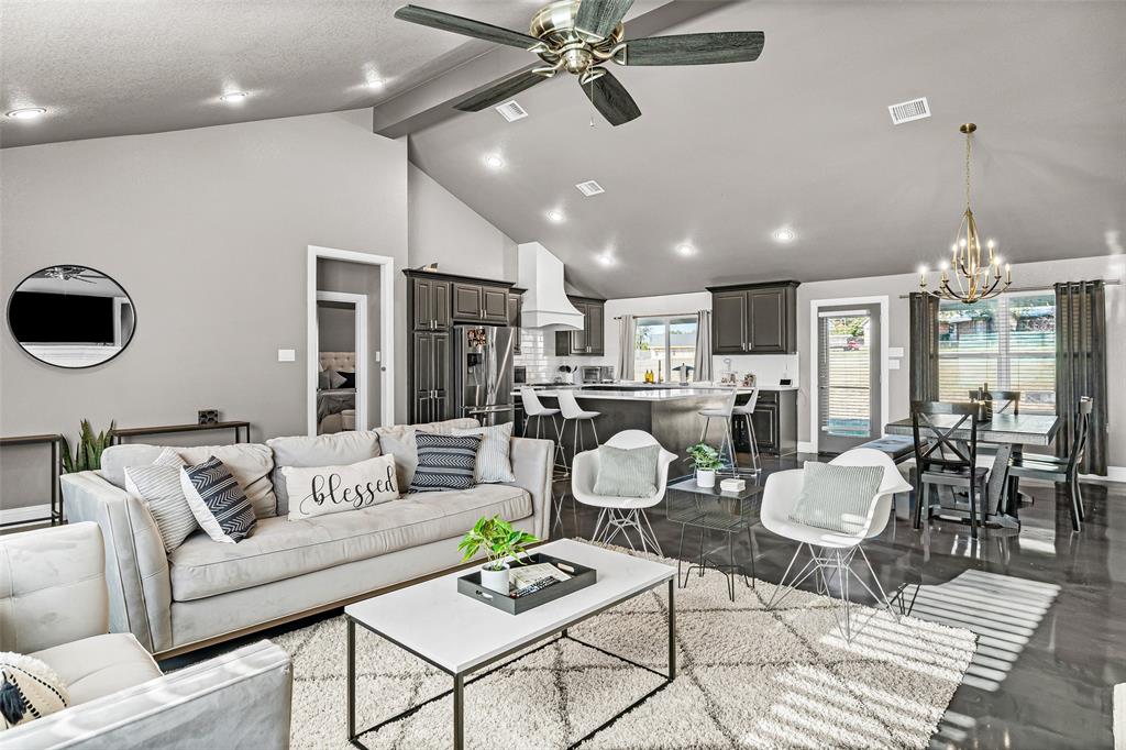 a living room with furniture kitchen view and a chandelier