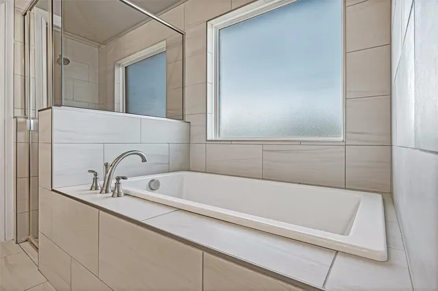 a spacious bathroom with a double vanity sink a mirror and a bathtub