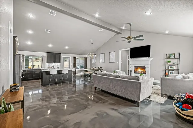 a living room with furniture a flat screen tv and a fireplace