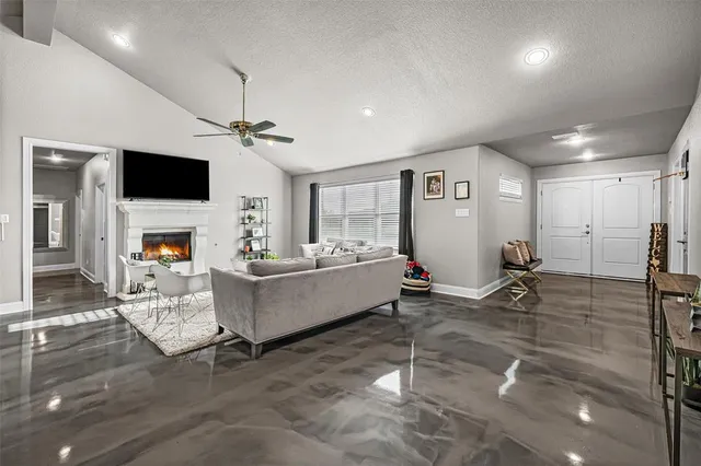 a living room with furniture a flat screen tv and a fireplace