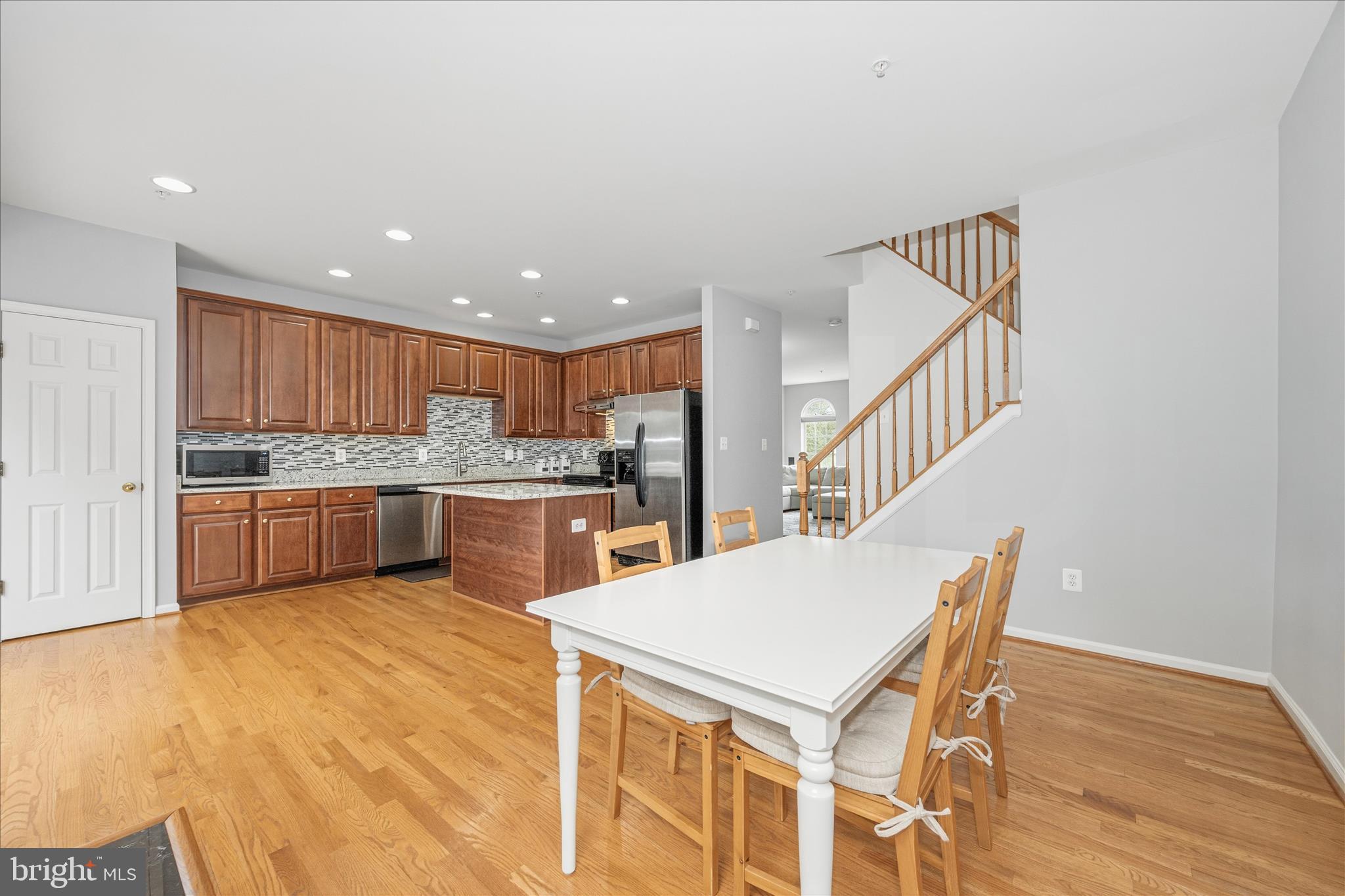 21 Inkberry Circle Gaithersburg, MD 20877 - Photo 12 of 51 a kitchen with a table chairs a sink dishwasher a refrigerator and cabinets with wooden floor