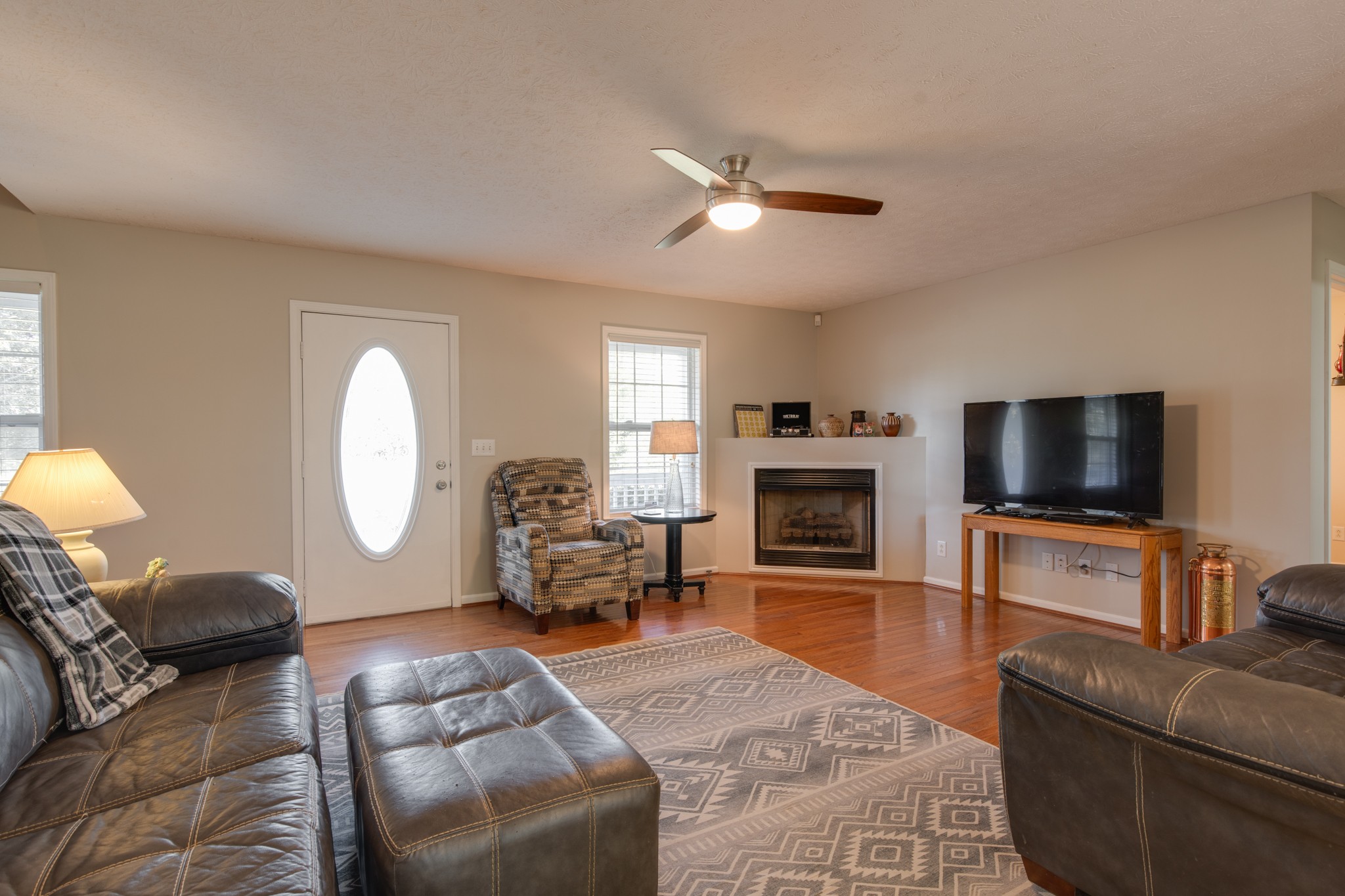 6699 East Benton Road Springfield, TN 37172 - Photo 58 of 66 a living room with furniture a fireplace and a flat screen tv