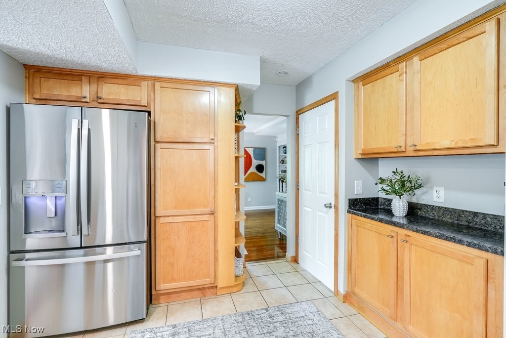 2340 Canterbury Road University Heights, OH 44118 - Photo 6 of 29 Kitchen featuring light tile patterned floors, light brown cabinetry, stainless steel refrigerator with ice dispenser, and a textured ceiling