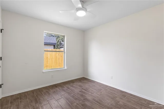 an empty room with a window and wooden floor