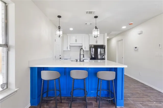 a kitchen with stainless steel appliances granite countertop a sink and a refrigerator