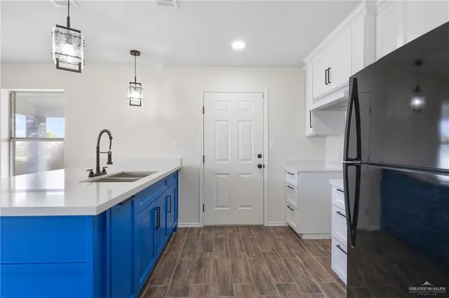 a kitchen with sink refrigerator and cabinets