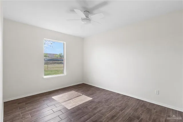 an empty room with wooden floor and window