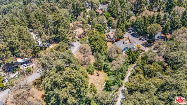 an aerial view of residential house with outdoor space and trees all around
